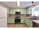 Stylish kitchen featuring mint-green cabinets, stainless steel appliances, and butcher block countertops at 589 Fox Creek Xing, Woodstock, GA 30188