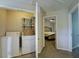 Convenient laundry area with washer, dryer, and shelving for storage; bedroom visible through open door at 589 Fox Creek Xing, Woodstock, GA 30188