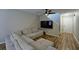 Comfortable living room features a large sectional sofa, modern ceiling fan, and wood-look flooring at 589 Fox Creek Xing, Woodstock, GA 30188
