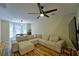 Cozy living room with a plush sectional sofa, modern ceiling fan, and warm wood flooring at 589 Fox Creek Xing, Woodstock, GA 30188