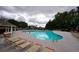 Large community pool surrounded by lounge chairs, tables and greenery at 589 Fox Creek Xing, Woodstock, GA 30188
