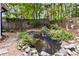 Private backyard oasis featuring a tranquil pond with lush greenery and a charming waterfall at 2849 Beddington Way, Suwanee, GA 30024