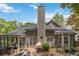 A serene backyard featuring a brick patio, covered seating, and a beautifully landscaped pond at 2849 Beddington Way, Suwanee, GA 30024