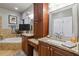 Elegant bathroom featuring granite counters, cherry cabinets, bathtub and decorative mirror at 2849 Beddington Way, Suwanee, GA 30024