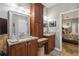 Elegant bathroom featuring granite counters, cherry cabinets, double vanity, and decorative mirror at 2849 Beddington Way, Suwanee, GA 30024