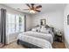 Bright bedroom with a large window, a ceiling fan, neutral paint, and comfortable bedding with decorative pillows at 2849 Beddington Way, Suwanee, GA 30024