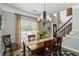 Formal dining room featuring a wooden table, chandelier, and natural light near the stairway at 2849 Beddington Way, Suwanee, GA 30024