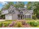 Charming two-story home featuring a two-car garage, manicured lawn and flower garden at 2849 Beddington Way, Suwanee, GA 30024