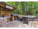 Outdoor grilling area featuring a built-in grill, wood storage, and seating, perfect for entertaining at 2849 Beddington Way, Suwanee, GA 30024
