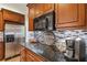 Close-up of kitchen with stainless steel appliances, including refrigerator and microwave, with granite countertops at 2849 Beddington Way, Suwanee, GA 30024