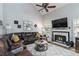 Cozy living room with a fireplace, ceiling fan, and comfortable leather seating at 2849 Beddington Way, Suwanee, GA 30024