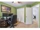 Home office space with an open door, featuring neutral carpeting, closet space and modern decorative art at 2849 Beddington Way, Suwanee, GA 30024
