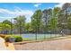 Community tennis court surrounded by lush greenery, perfect for enjoying a game in a peaceful setting at 2849 Beddington Way, Suwanee, GA 30024