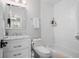 Bright bathroom with a shower-tub combo, white vanity with marble top, and a decorative mirror at 3265 Bentwood Close, Cumming, GA 30041