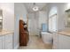 This bathroom features a soaking tub under a window, vanity and wood cabinet at 3265 Bentwood Close, Cumming, GA 30041