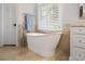 Bathroom featuring a modern soaking tub, shuttered window, and stone flooring at 3265 Bentwood Close, Cumming, GA 30041