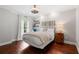 Bedroom with hardwood floors and neutral decor, illuminated by soft lamp light at 3265 Bentwood Close, Cumming, GA 30041