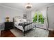 Bright bedroom featuring a large window, area rug, dark wood floors, and comfortable queen bed at 3265 Bentwood Close, Cumming, GA 30041