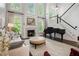 Elegant living room with a fireplace, hardwood floors, large windows, a piano, and a staircase at 3265 Bentwood Close, Cumming, GA 30041