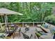 Inviting outdoor deck with comfortable patio seating, a glass dining table, and a shaded umbrella at 3265 Bentwood Close, Cumming, GA 30041