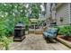 Cozy outdoor patio with a fireplace, comfortable seating, and views of the lush backyard at 3265 Bentwood Close, Cumming, GA 30041