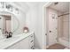 Bathroom with white vanity, black fixtures, and a view to a tiled shower/tub with glass door at 3851 Glenhurst Se Dr, Smyrna, GA 30080