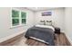 Cozy bedroom featuring hardwood floors, soft gray walls, a large window and a comfortable bed with decorative pillows at 3851 Glenhurst Se Dr, Smyrna, GA 30080