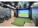 Home golf simulator setup with projector screen, turf, and bar stools in a room with dark walls and recessed lighting at 3851 Glenhurst Se Dr, Smyrna, GA 30080