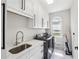 Bright laundry room with white cabinets, stainless steel sink, and modern washer and dryer at 3851 Glenhurst Se Dr, Smyrna, GA 30080
