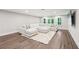 Bright open-plan living room with large white sectional sofa, neutral walls, light wood floors, and white rug at 3851 Glenhurst Se Dr, Smyrna, GA 30080