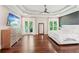 Large main bedroom featuring tray ceiling, hardwood flooring, dresser, and a private balcony at 3851 Glenhurst Se Dr, Smyrna, GA 30080
