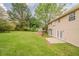 Backyard with lush green grass, mature trees, and a patio at 6351 Stablewood Way, Lithonia, GA 30058