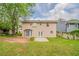 Backyard with lush green grass, mature trees, and a patio at 6351 Stablewood Way, Lithonia, GA 30058