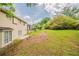 Backyard with lush green grass, mature trees, and a patio at 6351 Stablewood Way, Lithonia, GA 30058