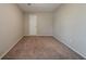 Bedroom with light walls, tan carpet, bright light fixture and a door at 6351 Stablewood Way, Lithonia, GA 30058