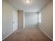 Bedroom with light walls, tan carpet, bright light fixture and a window at 6351 Stablewood Way, Lithonia, GA 30058