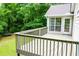 A back deck with gray painted railings and a view of the wooded back yard at 9691 Squirrel Wood Run, Douglasville, GA 30135