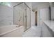 Bright bathroom with marble floors, a tub, glass enclosed shower, and granite countertops at 9691 Squirrel Wood Run, Douglasville, GA 30135