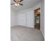 A bedroom featuring neutral carpet, a ceiling fan, and a closet with bi-fold doors at 9691 Squirrel Wood Run, Douglasville, GA 30135