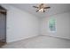 A bedroom featuring neutral carpet, a ceiling fan, and a window overlooking green trees at 9691 Squirrel Wood Run, Douglasville, GA 30135