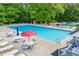 Community swimming pool featuring plenty of lounge chairs and tables with umbrellas at 9691 Squirrel Wood Run, Douglasville, GA 30135