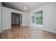 Open dining room with wood floors, modern light fixture, and large windows at 9691 Squirrel Wood Run, Douglasville, GA 30135