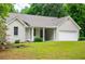 Charming single-story home featuring an attached garage, landscaped yard, and covered entry at 9691 Squirrel Wood Run, Douglasville, GA 30135