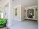 This home boasts a covered front porch, sturdy support columns, and detailed entry door with sidelights at 9691 Squirrel Wood Run, Douglasville, GA 30135