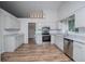 Modern kitchen featuring stainless steel appliances, granite countertops, and wood-look flooring at 9691 Squirrel Wood Run, Douglasville, GA 30135