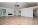 Bright living room with laminate floors, white walls, a fireplace, and large windows showcasing outdoor views at 9691 Squirrel Wood Run, Douglasville, GA 30135