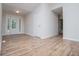 Spacious living room with stylish laminate floors, white trim, and a front door with sidelights at 9691 Squirrel Wood Run, Douglasville, GA 30135