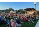 A crowd of people sit on a lawn in front of the stage at the amphitheater at 1932 Appian Aly, Kennesaw, GA 30144