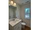 Cozy bathroom with a white vanity, toilet, and a window view, offering natural light at 1932 Appian Aly, Kennesaw, GA 30144