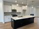 Modern kitchen features white cabinets, stainless steel appliances, and a large black island with white countertop at 1932 Appian Aly, Kennesaw, GA 30144